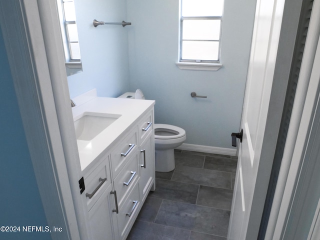 bathroom with vanity, toilet, and a healthy amount of sunlight