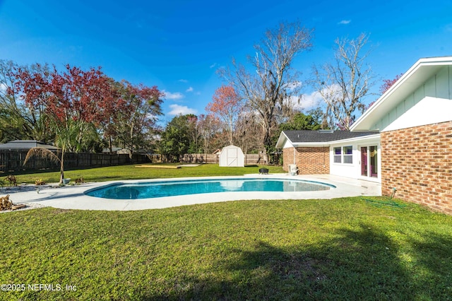 view of pool featuring a lawn, a patio, and a storage unit