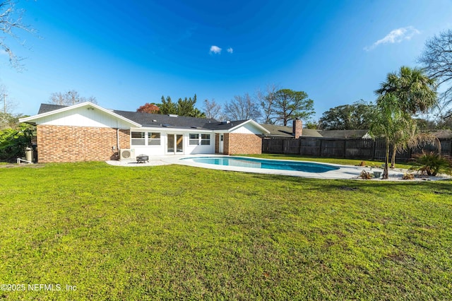 rear view of house featuring a yard and a fenced in pool