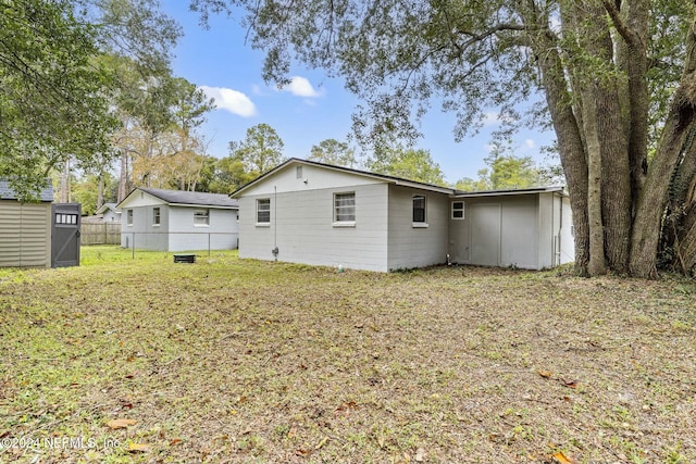 rear view of house featuring a shed