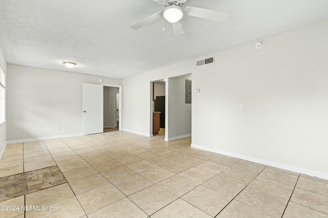 unfurnished room featuring ceiling fan, light tile patterned floors, and a textured ceiling