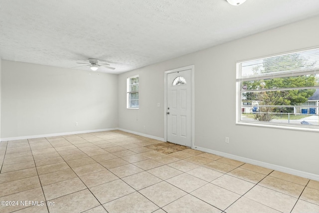 tiled foyer featuring a textured ceiling and ceiling fan