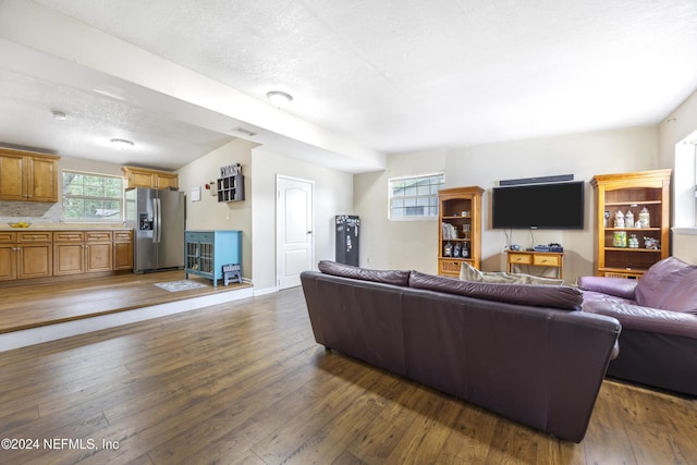 living room with dark hardwood / wood-style flooring and a textured ceiling