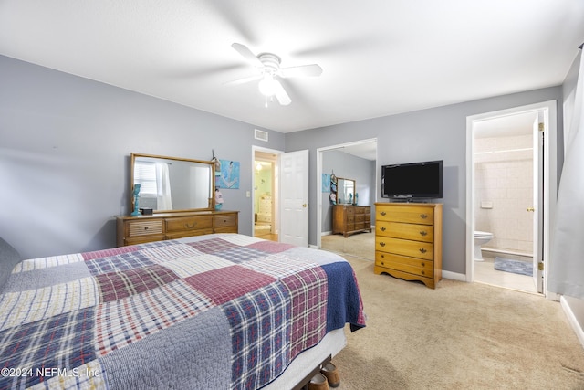 carpeted bedroom with ensuite bathroom and ceiling fan