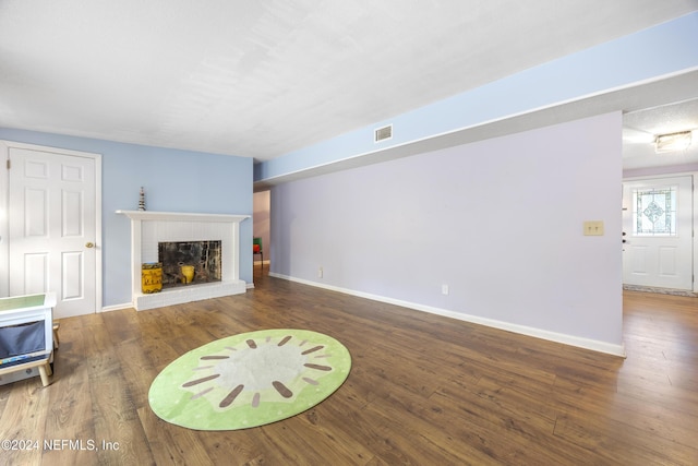 unfurnished living room featuring a fireplace and dark wood-type flooring