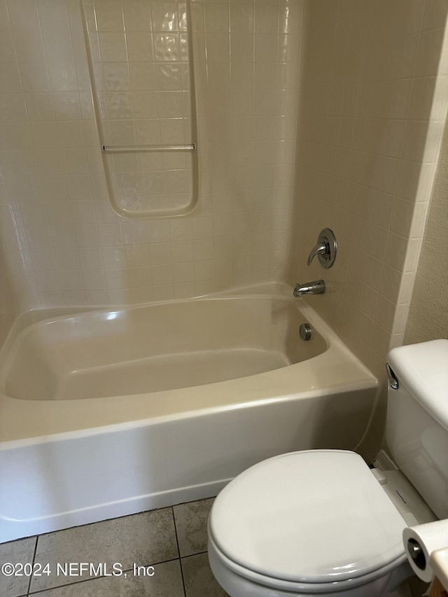 bathroom with tile patterned flooring, shower / bathing tub combination, and toilet