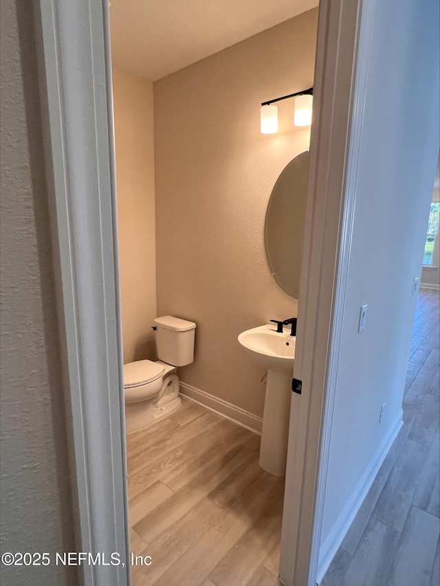 bathroom with sink, toilet, and hardwood / wood-style flooring