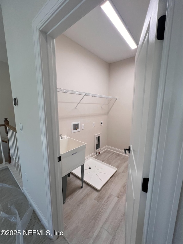 laundry area featuring hookup for a washing machine, electric dryer hookup, and light hardwood / wood-style flooring