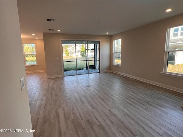 spare room featuring plenty of natural light and light hardwood / wood-style flooring