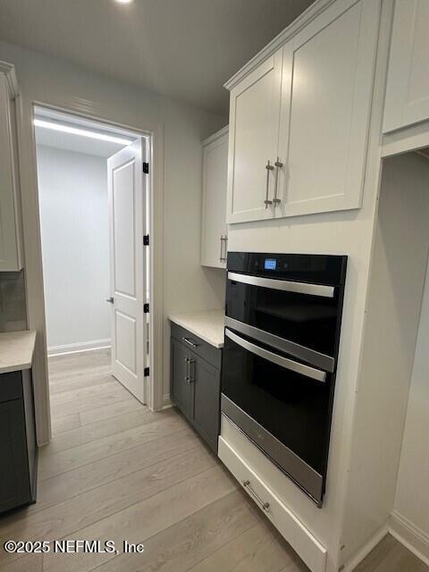 kitchen featuring white cabinetry, double wall oven, and light hardwood / wood-style floors