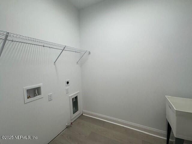 laundry room with dark wood-type flooring, hookup for a washing machine, and electric dryer hookup