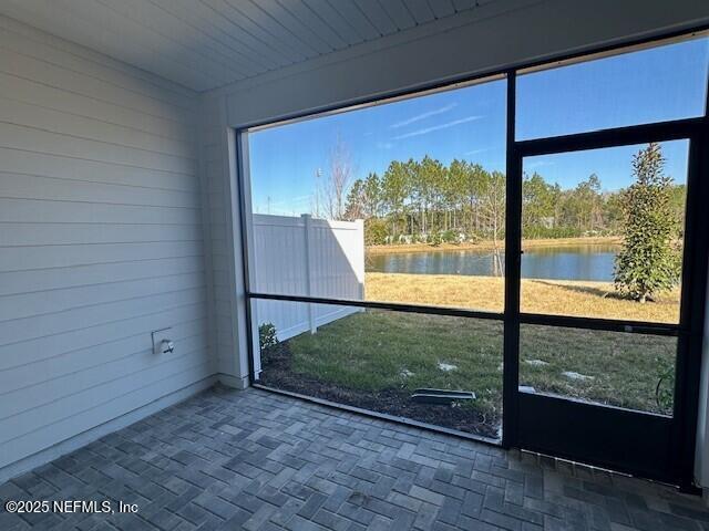 unfurnished sunroom with a water view