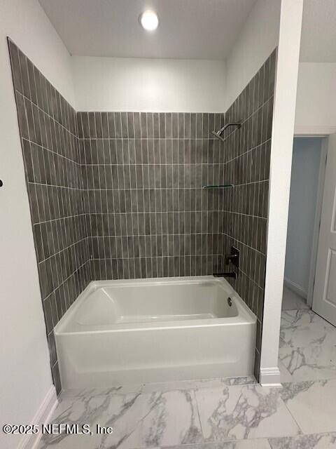 bathroom featuring tiled shower / bath