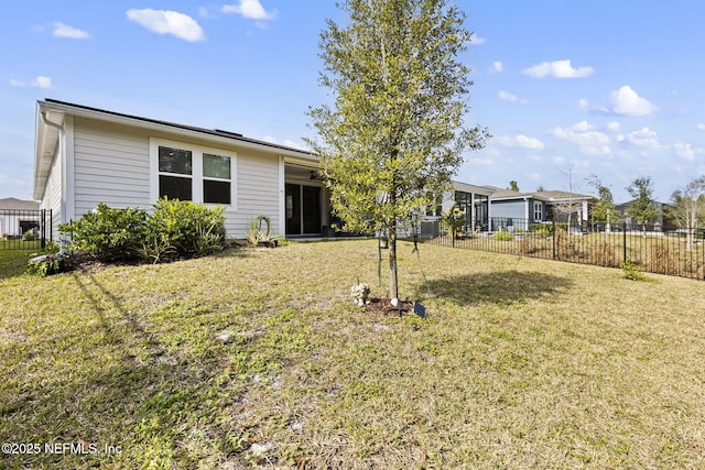 rear view of property featuring a lawn