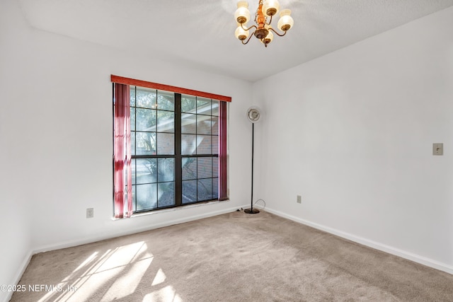 carpeted spare room with a notable chandelier