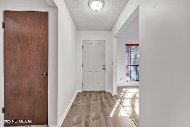 hallway featuring a textured ceiling and light wood-type flooring