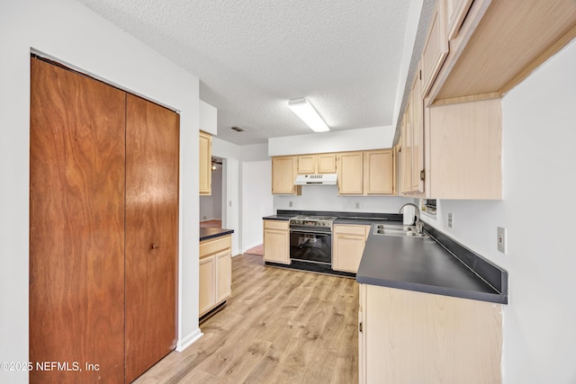 kitchen with stainless steel stove, sink, light hardwood / wood-style flooring, light brown cabinets, and a textured ceiling