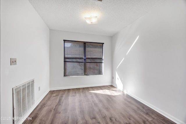 spare room with wood-type flooring and a textured ceiling