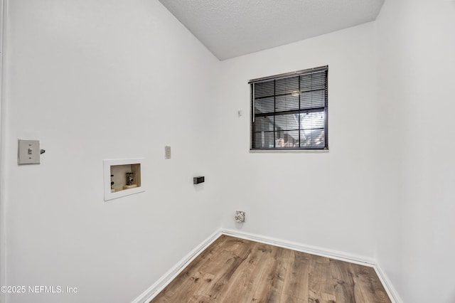 laundry area with hardwood / wood-style flooring, washer hookup, and a textured ceiling