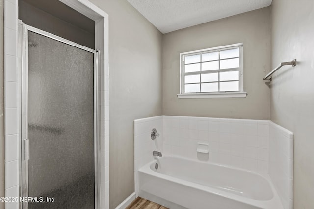 bathroom featuring a textured ceiling, independent shower and bath, and hardwood / wood-style floors