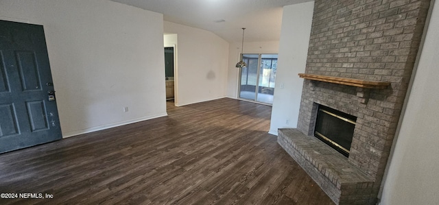 unfurnished living room featuring dark hardwood / wood-style flooring, lofted ceiling, and a brick fireplace