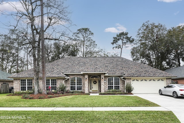 ranch-style home with a garage and a front lawn