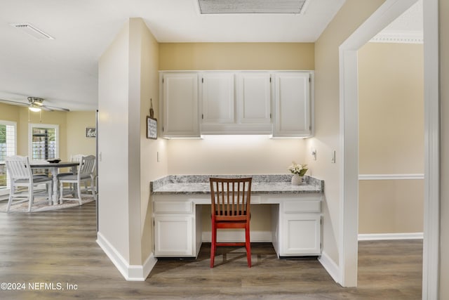 office space with ceiling fan, hardwood / wood-style floors, and built in desk