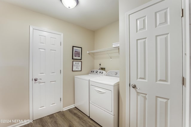 laundry area with washing machine and dryer and hardwood / wood-style floors