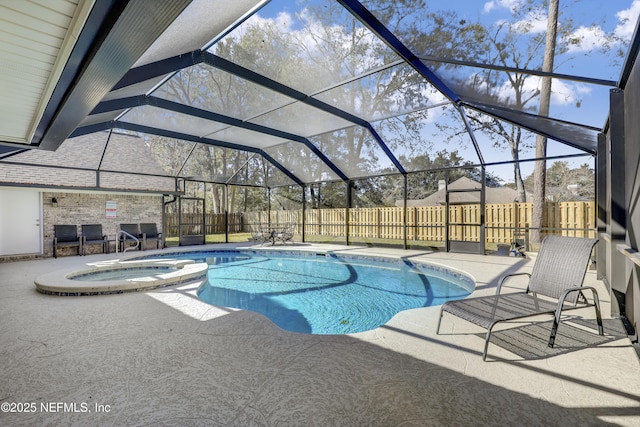 view of swimming pool featuring glass enclosure, a patio area, and an in ground hot tub