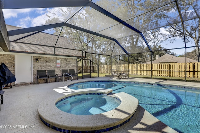 view of pool with an in ground hot tub, glass enclosure, and a patio