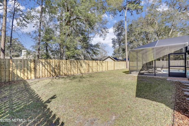 view of yard featuring a swimming pool and glass enclosure