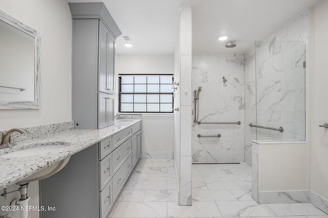 bathroom featuring a tile shower and vanity