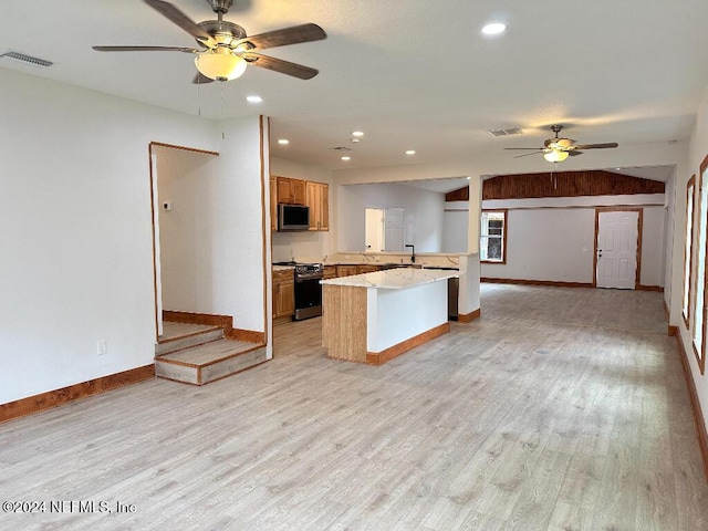 kitchen with ceiling fan, range, kitchen peninsula, a kitchen island, and light wood-type flooring