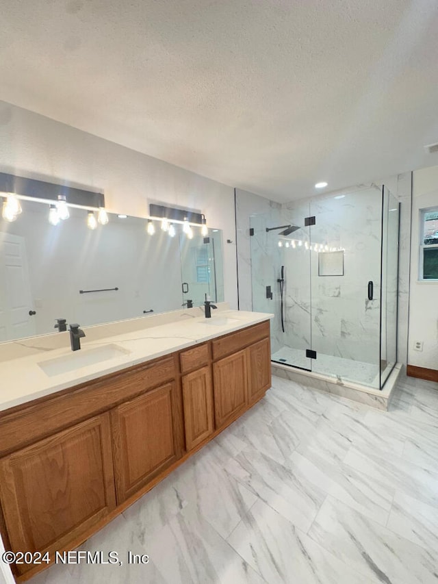 bathroom featuring vanity, a textured ceiling, and a shower with shower door