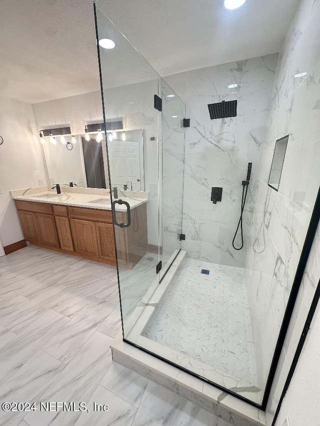 bathroom featuring a shower with door and vanity