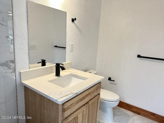 bathroom featuring tile patterned flooring, vanity, and toilet