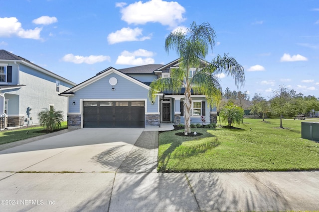 view of front of property featuring a garage, a balcony, and a front yard