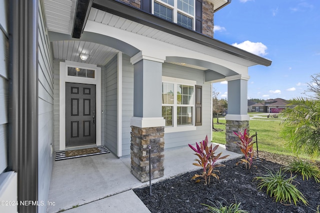 entrance to property with a yard and a porch