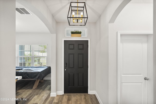 foyer entrance with a chandelier, wood-type flooring, and pool table