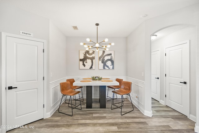 dining room with breakfast area, light hardwood / wood-style floors, and a chandelier