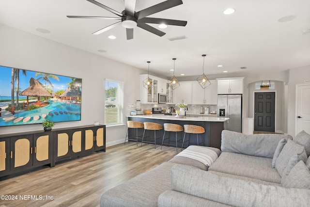 living room featuring ceiling fan and light wood-type flooring