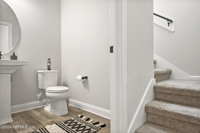 bathroom with hardwood / wood-style flooring and toilet