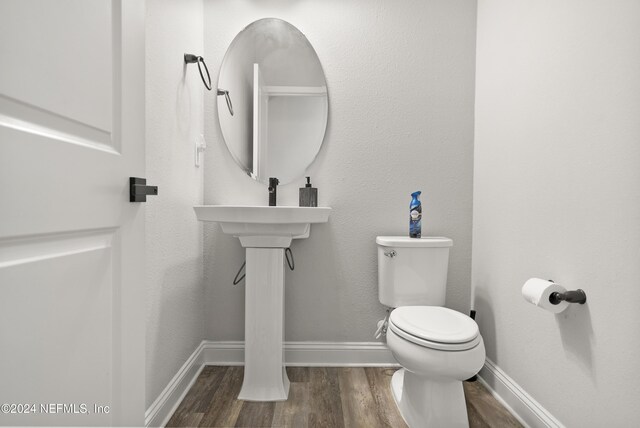 bathroom featuring toilet and wood-type flooring