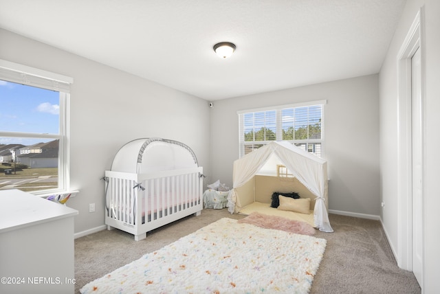 bedroom with carpet flooring and a crib