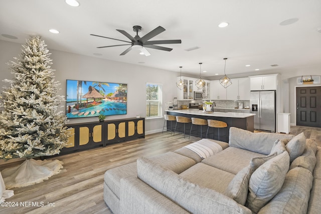 living room featuring ceiling fan and light wood-type flooring