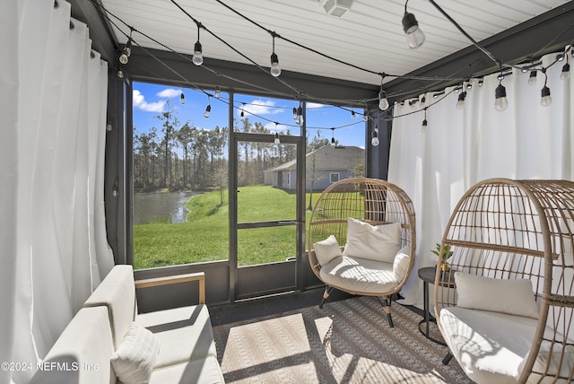 sunroom featuring a water view