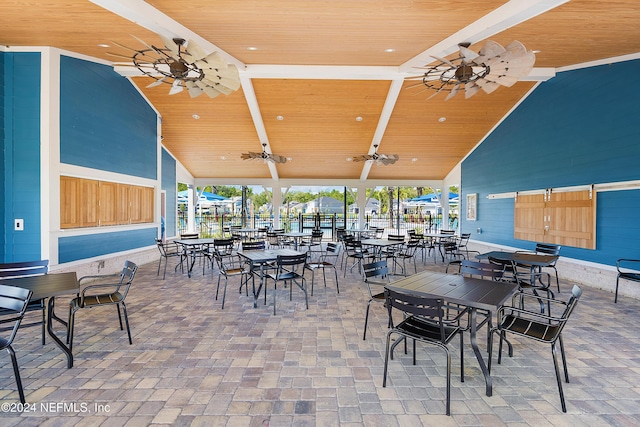 dining area with beamed ceiling, ceiling fan, wooden ceiling, and high vaulted ceiling