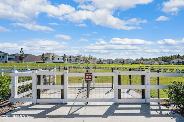 view of gate with a lawn