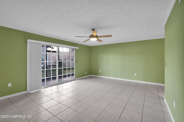 unfurnished room featuring ceiling fan, light tile patterned floors, and a textured ceiling