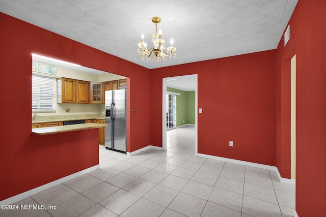 kitchen featuring pendant lighting, kitchen peninsula, light tile patterned flooring, stainless steel fridge with ice dispenser, and a chandelier